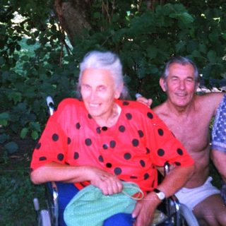 Four adults posing together outdoors in casual attire.