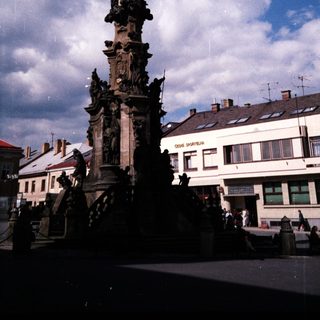 Baroque-style column monument in public square.