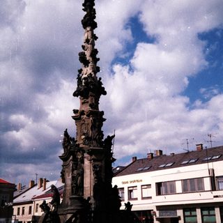 Baroque-style column monument in public square.