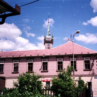 Historic building with clock tower, pink facade.