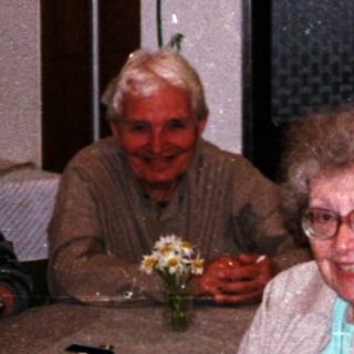 Group of elderly people enjoying drinks indoors.