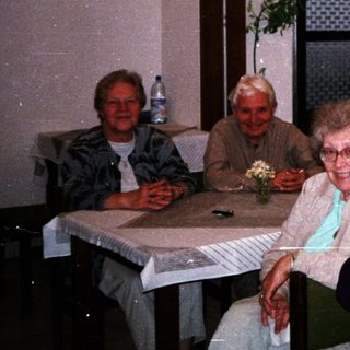 Group of elderly people enjoying drinks indoors.