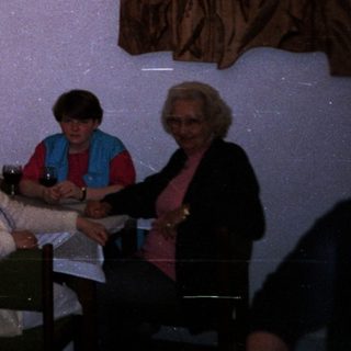 Group of elderly people gathered indoors for a social event.