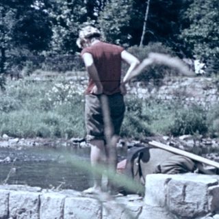 People fishing near a small waterfall.