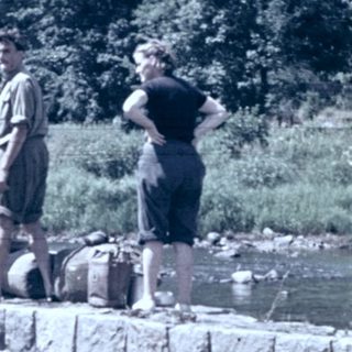 People fishing near a small waterfall.