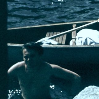 Person launching canoe into flowing river.