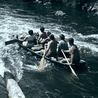 Group rowing boat on turbulent river.