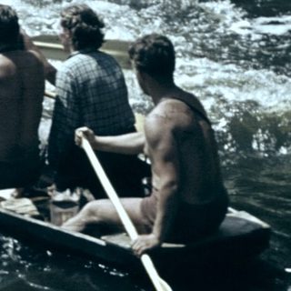 Group rowing boat on turbulent river.