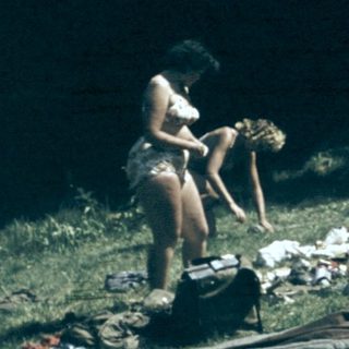 People camping outdoors with tent and gear.