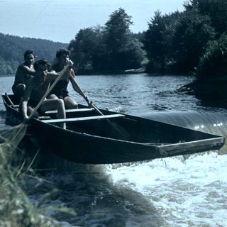 Two people rowing a canoe on a river.