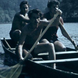 Two people rowing a canoe on a river.
