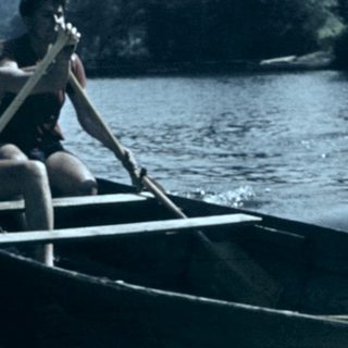 Two people rowing a canoe on a river.