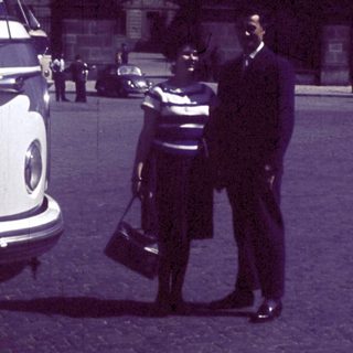 Classic car parked near man in uniform.