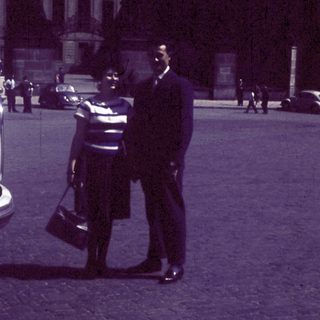 Classic car parked near man in uniform.