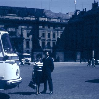 Vintage street scene with couple talking near bus.