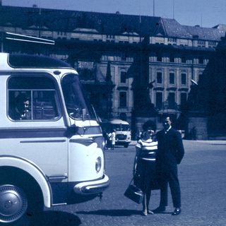 Vintage street scene with couple talking near bus.