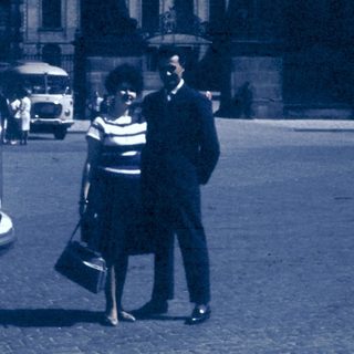 Vintage street scene with couple talking near bus.