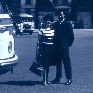Vintage street scene with couple talking near bus.