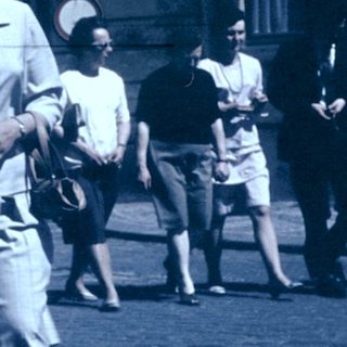 Family walking together in vintage street attire.
