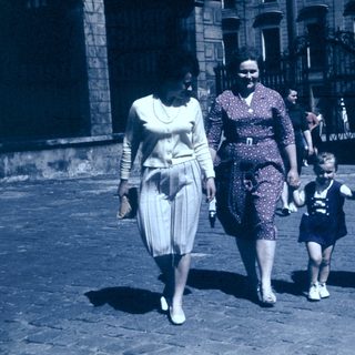 Family walking together in vintage street attire.