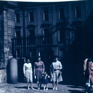 Group of people walking outdoors in vintage clothing.
