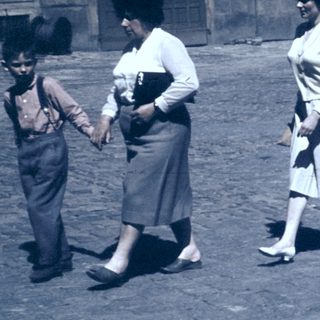 Family walking in courtyard near historic building.