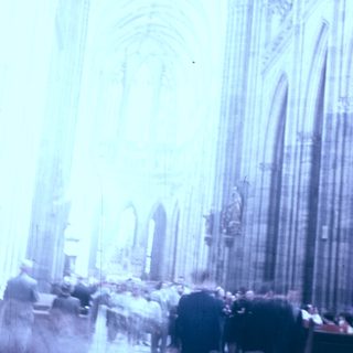 Gothic cathedral interior with blurred crowd.