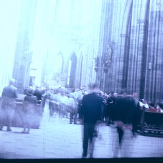 Gothic cathedral interior with blurred crowd.