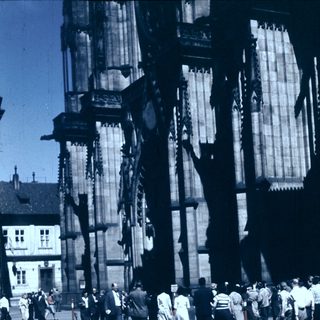 Historic cathedral scaffolding with workers and visitors.