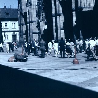 Historic cathedral scaffolding with workers and visitors.