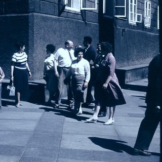 People standing in line outdoors during daytime.