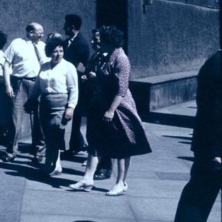 People standing in line outdoors during daytime.