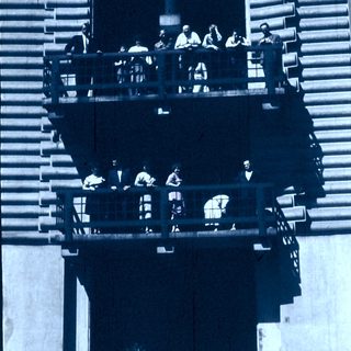 People sitting on multi-level outdoor viewing platform.