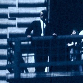 People sitting on multi-level outdoor viewing platform.