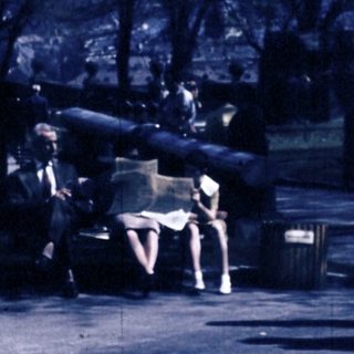 People walking and sitting in park area.