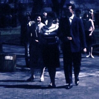 People walking and sitting in park area.