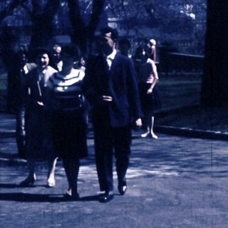 People walking and sitting in park area.