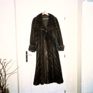 Vintage fur-lined long coat on hanger.