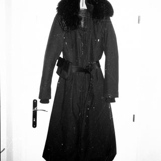 Dark overcoat with fur collar and belt.