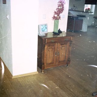 Flooded room with water-covered wooden floor.