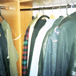 Clothes hanging on indoor coat rack.