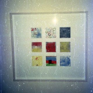 Colorful stained glass art fragments in a frame.