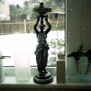 Vintage statue lamp beside winter window sill.