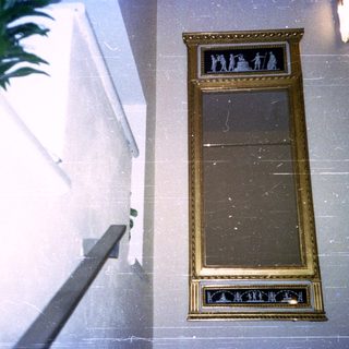 Elegant gold-framed mirror with decorative carvings.