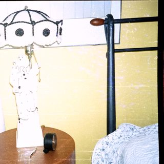 Vintage lamp on round table beside bed.
