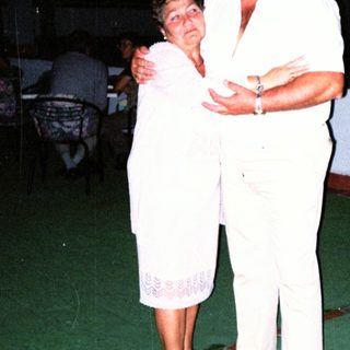 Couple dancing together indoors at night.