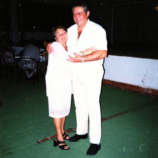 Couple dancing together indoors at night.