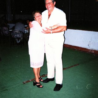 Couple dancing together indoors at night.