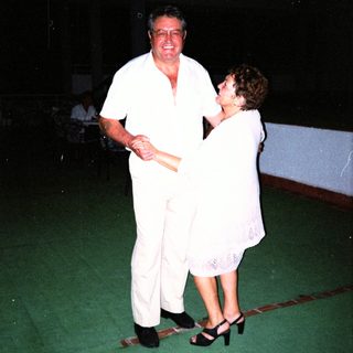 Couple dancing formally in white attire.