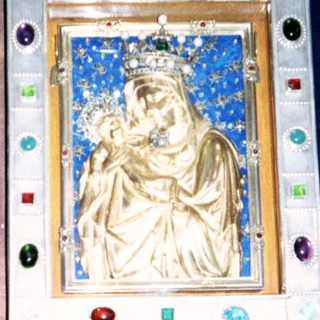 Religious shrine with crowned Madonna, heraldic lion crest.